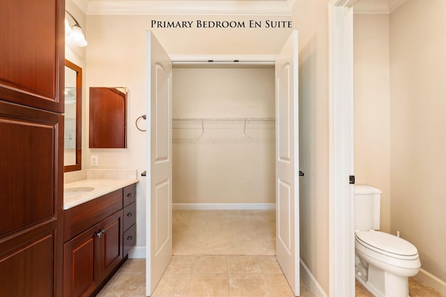 bathroom with tile patterned floors, vanity, toilet, and ornamental molding