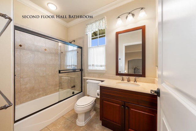 full bathroom featuring vanity, bath / shower combo with glass door, crown molding, tile patterned flooring, and toilet