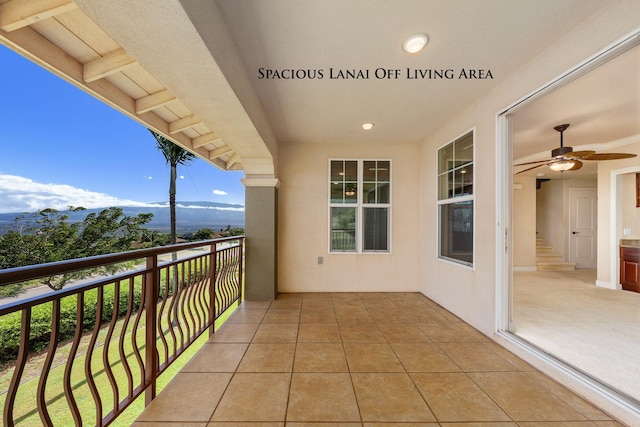 balcony featuring a mountain view and ceiling fan