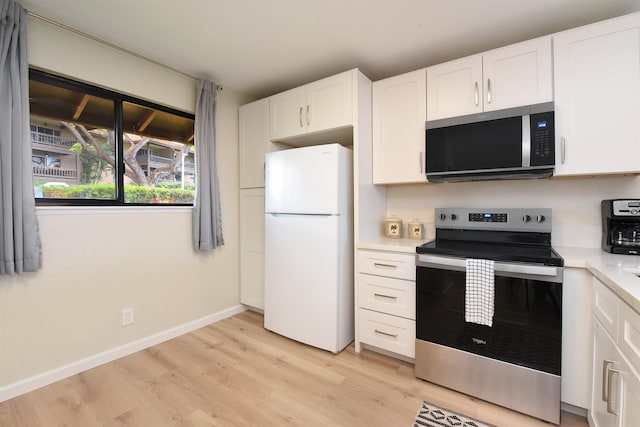kitchen with light countertops, white cabinetry, stainless steel appliances, and light wood-style floors