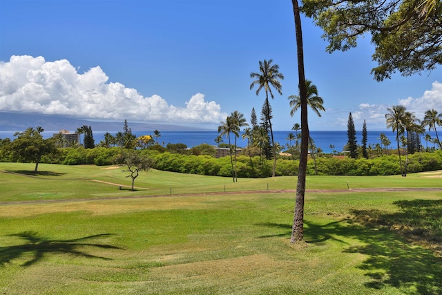 view of community with a lawn, a water view, and view of golf course