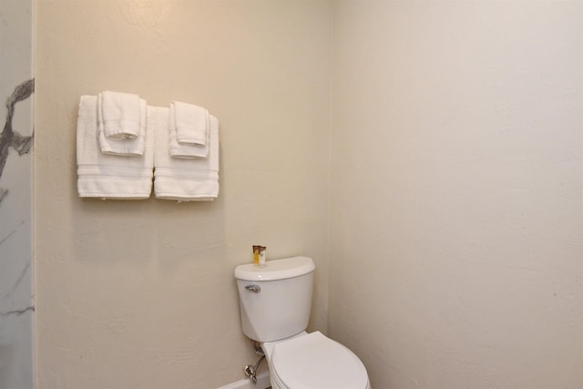 bathroom with baseboards and toilet