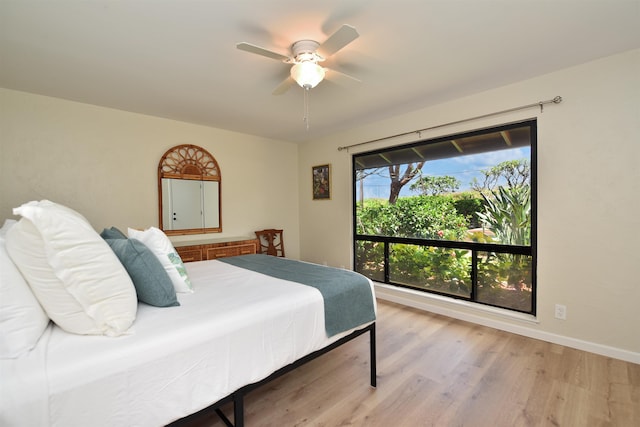 bedroom with a ceiling fan, light wood-style flooring, and baseboards