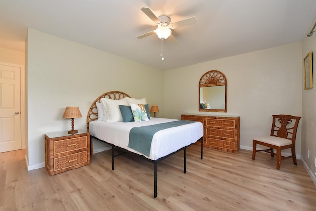 bedroom featuring a ceiling fan, baseboards, and light wood-style floors