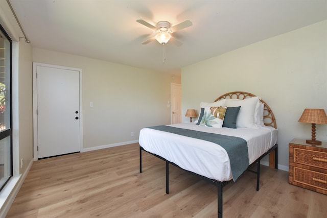 bedroom with a ceiling fan, light wood-style flooring, and baseboards