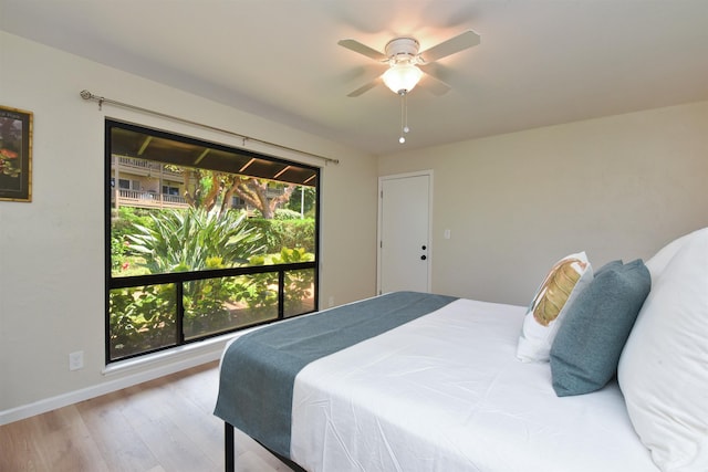 bedroom with wood finished floors, a ceiling fan, and baseboards