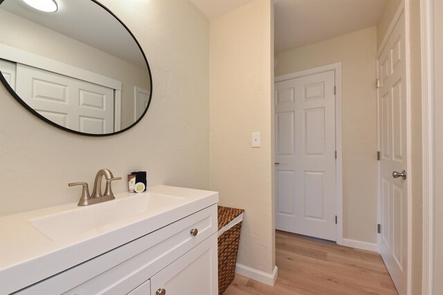 bathroom featuring wood finished floors, vanity, and baseboards