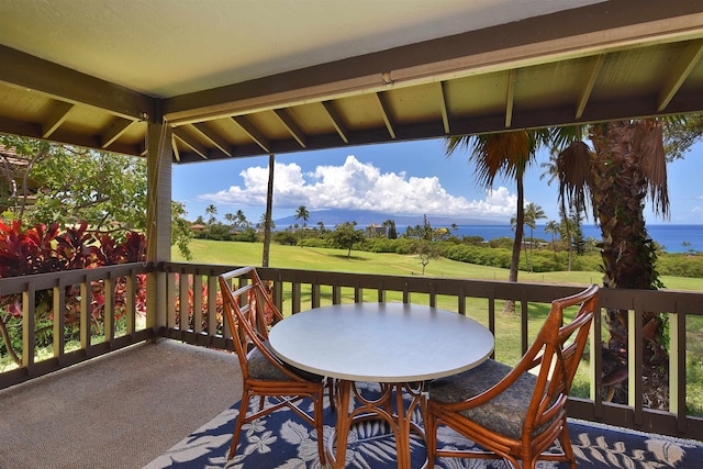 wooden terrace with a lawn, a water view, and view of golf course