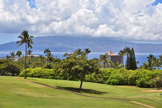 view of home's community featuring a water view, a yard, and view of golf course
