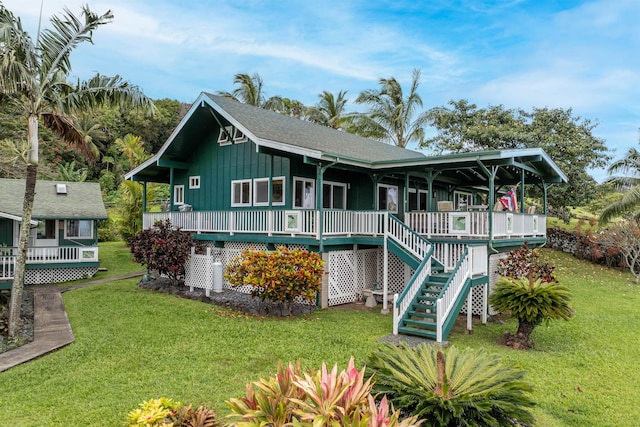 rear view of property with a deck and a yard