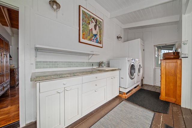 clothes washing area featuring cabinets, dark hardwood / wood-style flooring, wooden ceiling, washing machine and dryer, and sink