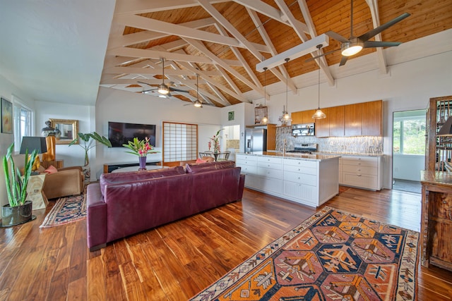 living room with dark hardwood / wood-style floors, high vaulted ceiling, beam ceiling, and wood ceiling