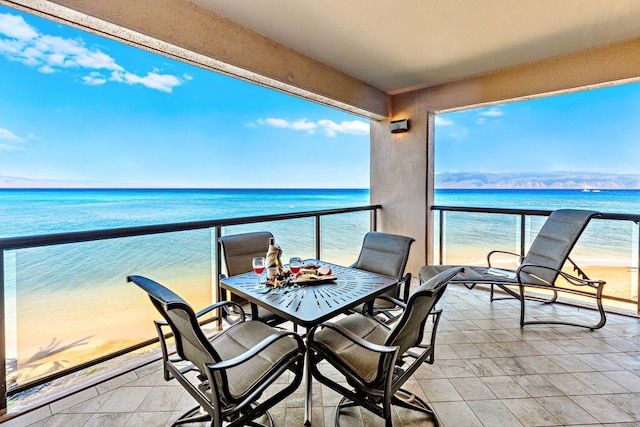 balcony featuring a beach view and a water view