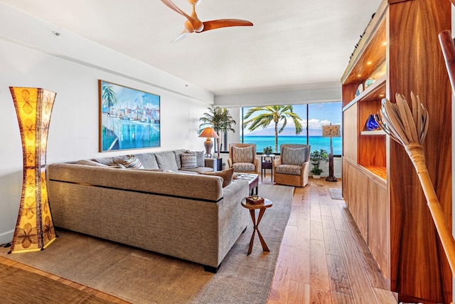 living room featuring a water view, ceiling fan, and light hardwood / wood-style floors