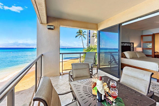 balcony featuring a beach view and a water view