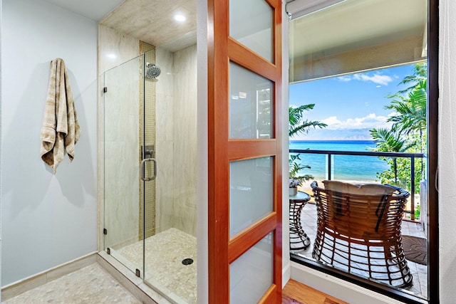 bathroom featuring a water view, wood-type flooring, and walk in shower