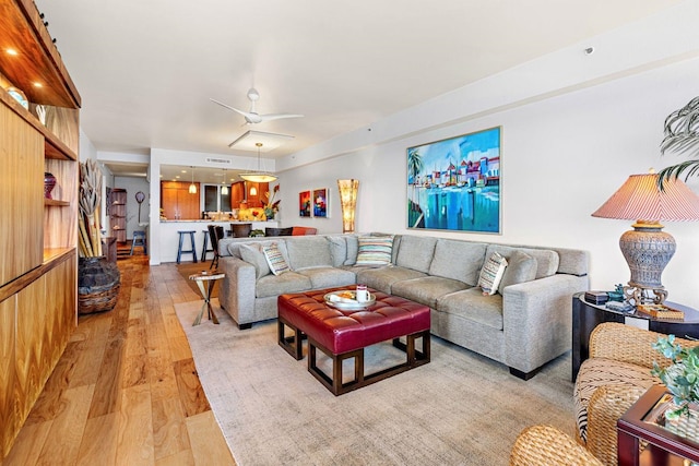 living room with ceiling fan and light wood-type flooring