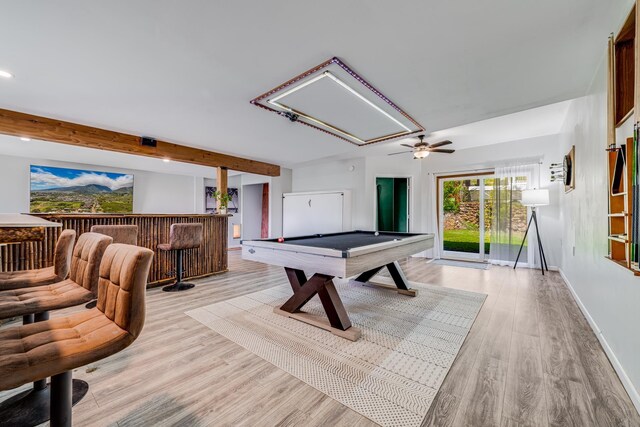 kitchen with a kitchen island, light hardwood / wood-style floors, stainless steel refrigerator, a kitchen bar, and tasteful backsplash