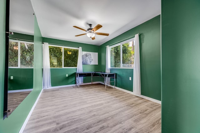 interior space featuring ceiling fan, wood finished floors, lofted ceiling, and baseboards