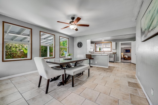 dining room featuring ceiling fan, a wealth of natural light, and baseboards