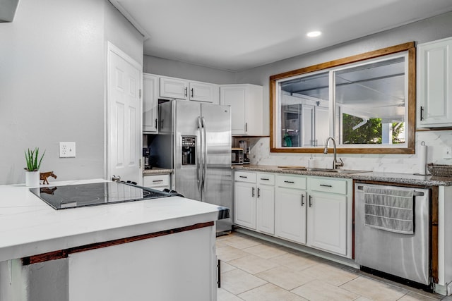 kitchen with white cabinets, tasteful backsplash, stainless steel appliances, and a sink