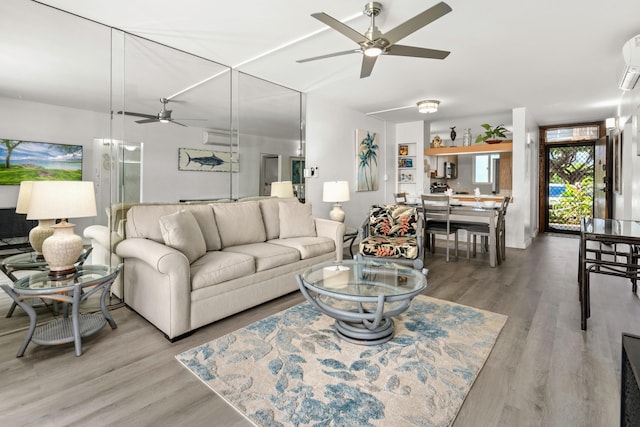 living room with a wall mounted air conditioner, hardwood / wood-style flooring, and ceiling fan