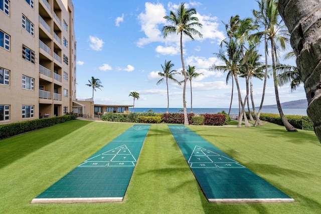 view of community with a water view and a lawn