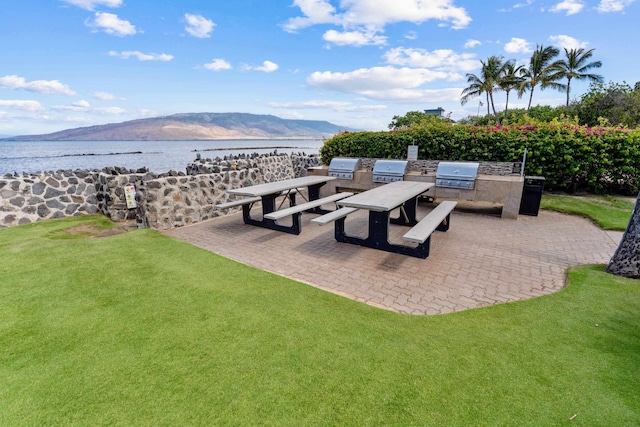 view of patio / terrace with an outdoor kitchen, grilling area, and a water and mountain view