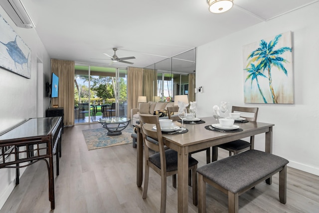 dining room with hardwood / wood-style floors, ceiling fan, floor to ceiling windows, and a wall mounted AC