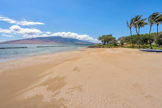 view of water feature with a mountain view and a view of the beach