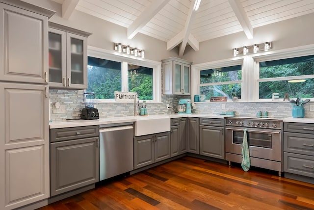 kitchen featuring light countertops, gray cabinets, stainless steel appliances, and tasteful backsplash