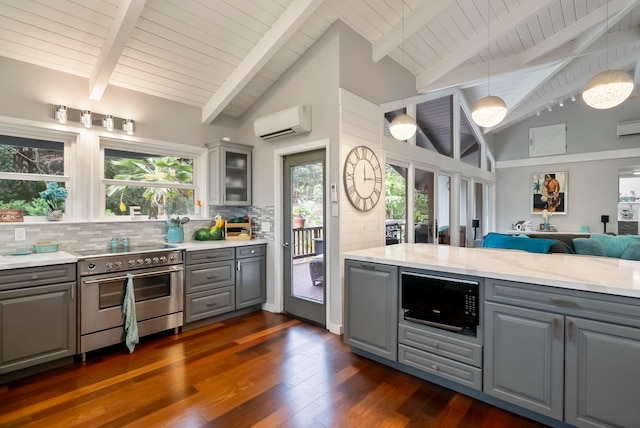 kitchen featuring open floor plan, a wall mounted air conditioner, gray cabinets, high end range, and black microwave