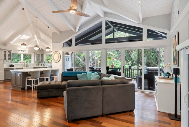 living room with hardwood / wood-style floors, wooden ceiling, high vaulted ceiling, beamed ceiling, and a ceiling fan