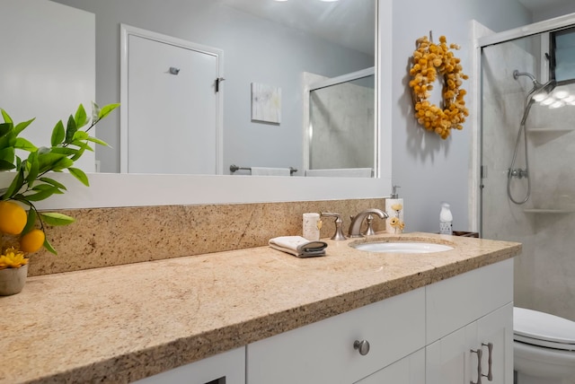 bathroom with toilet, a stall shower, and vanity