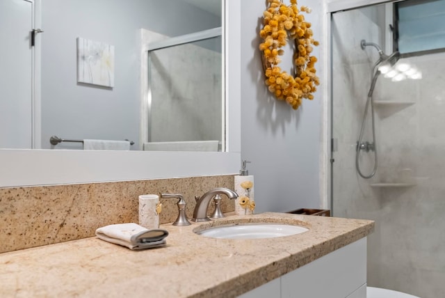 bathroom featuring toilet, a stall shower, and vanity