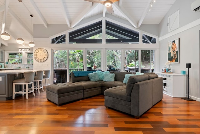 living room with a healthy amount of sunlight, beamed ceiling, and wood-type flooring