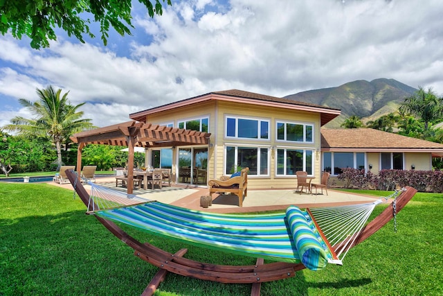 rear view of house with a swimming pool, a patio, a yard, a mountain view, and a pergola