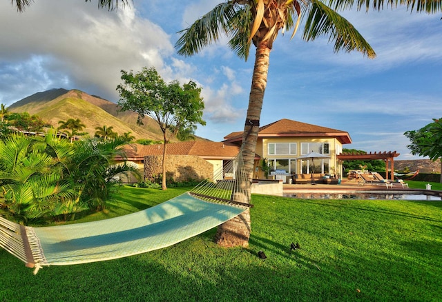 view of nearby features featuring a mountain view, a pergola, a patio area, and a lawn