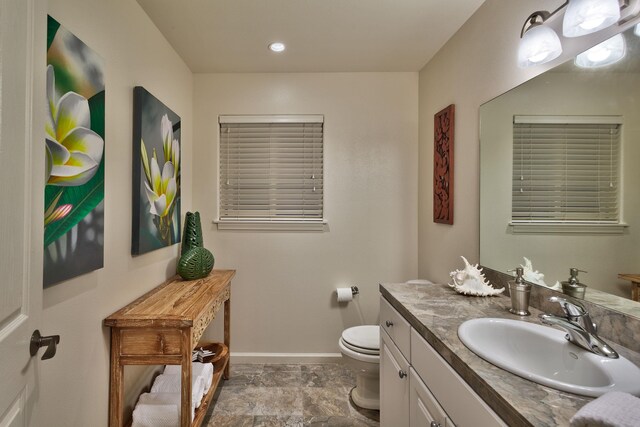 bathroom with toilet, large vanity, and tile flooring