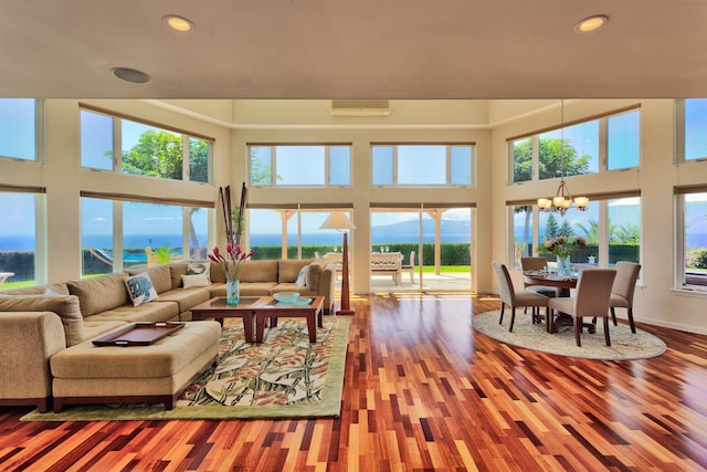 living room with a notable chandelier, plenty of natural light, and hardwood / wood-style flooring