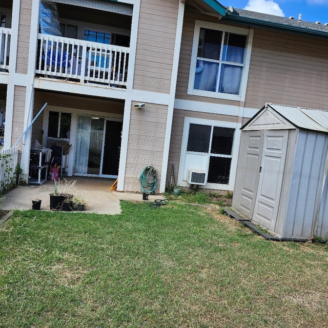 rear view of property with a yard, a patio, a shed, a balcony, and cooling unit