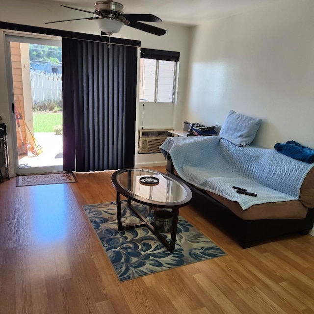 living room with cooling unit, wood-type flooring, and ceiling fan