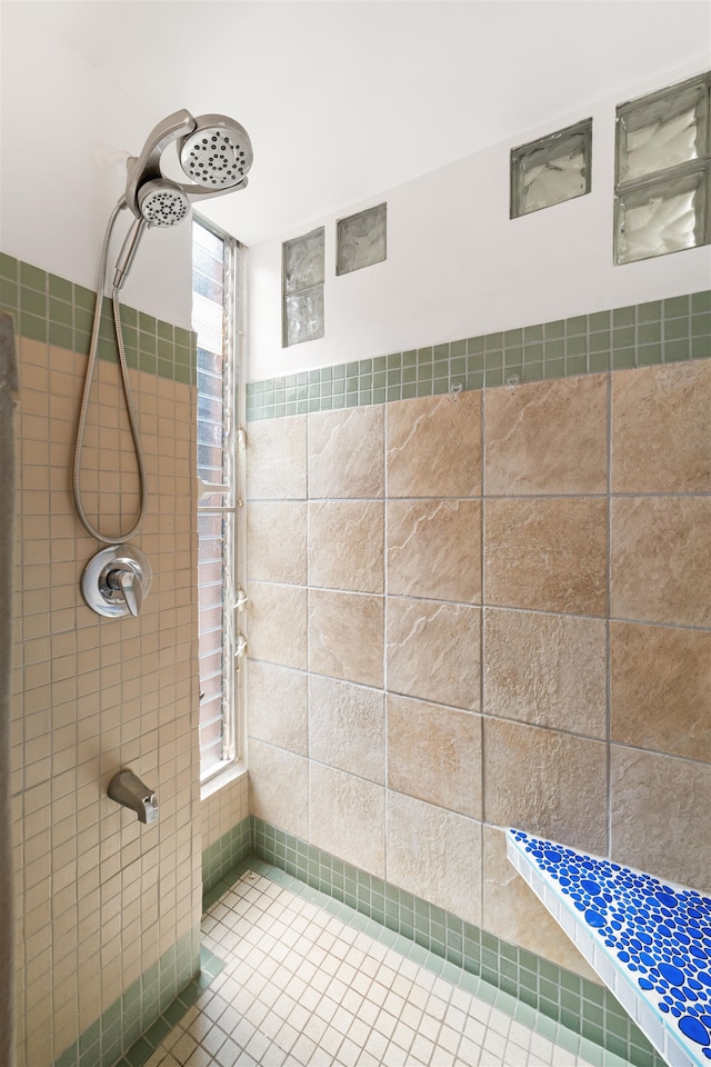 bathroom with a tile shower and tile patterned floors