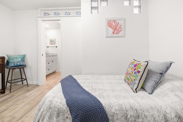 bedroom featuring light hardwood / wood-style flooring and ensuite bathroom