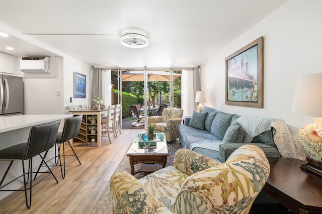 living room with light hardwood / wood-style floors and a wall mounted air conditioner