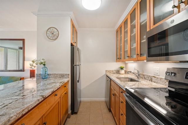 kitchen featuring light tile patterned floors, brown cabinetry, appliances with stainless steel finishes, crown molding, and a sink