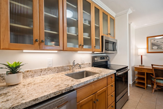 kitchen featuring light tile patterned floors, appliances with stainless steel finishes, light stone countertops, crown molding, and a sink