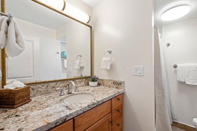 bathroom featuring curtained shower, vanity, and toilet