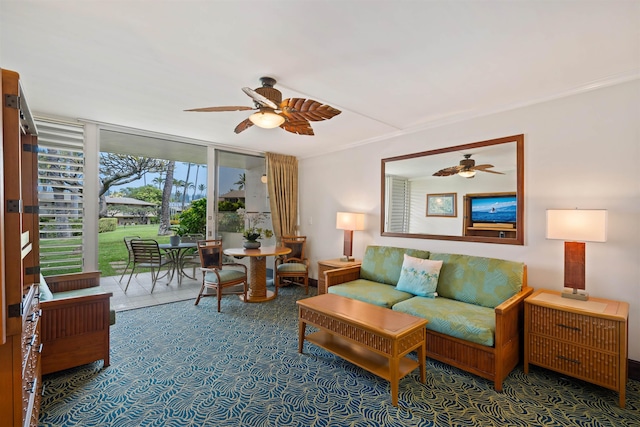 living area with ceiling fan, a wall of windows, and crown molding