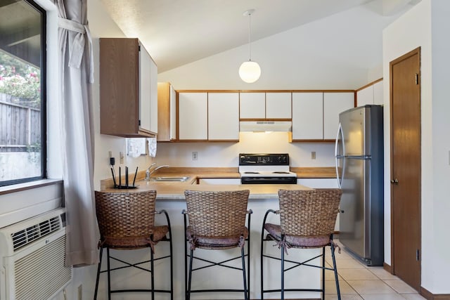 kitchen featuring electric stove, white cabinetry, a breakfast bar, and stainless steel refrigerator